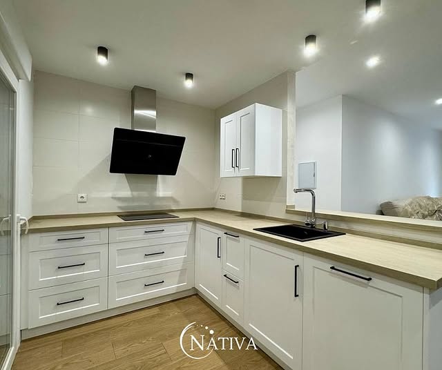 Cocina gris con cubierta de mármol y gabinetes altos, estilo moderno